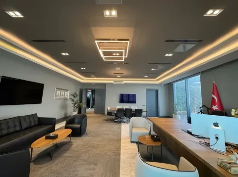 Deri oturma grubu ve toplantı masası bulunan yönetim ofisi